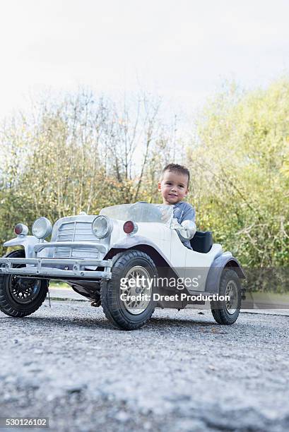 young kid boy driving model vintage car - auto fahren stock pictures, royalty-free photos & images