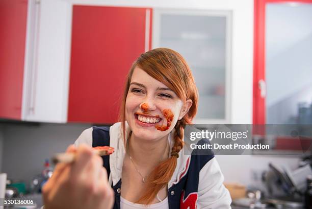 happy young woman got messy while eating tomato ketchup, munich, bavaria, germany - unvollkommenheit stock-fotos und bilder