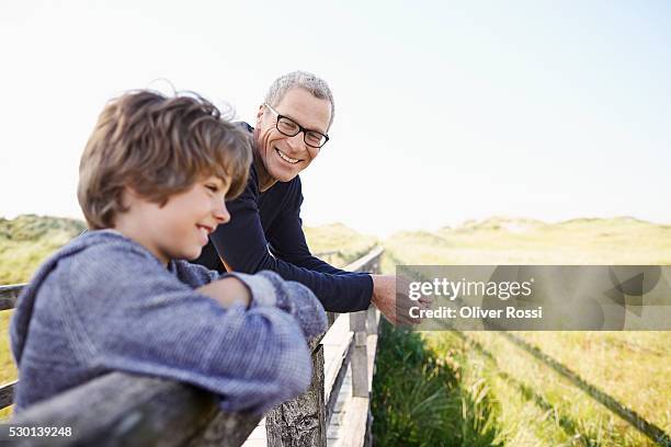 grandfather and grandson at the coast - railings stock pictures, royalty-free photos & images