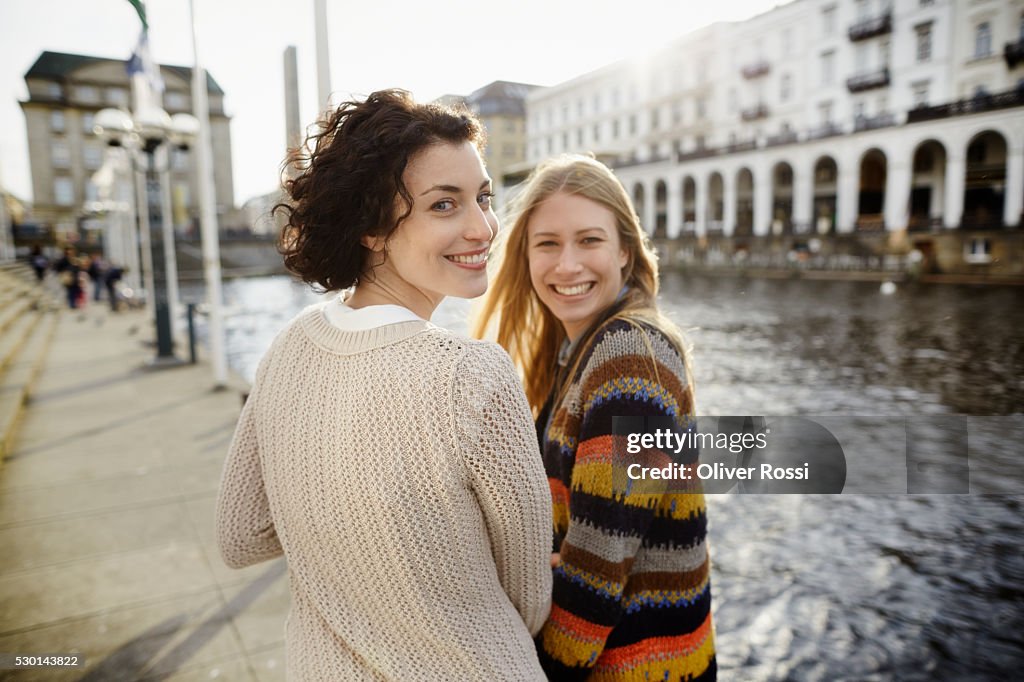 Portrait of two smiling young women by the riverside