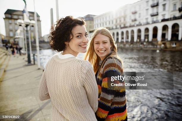 portrait of two smiling young women by the riverside - behind the scenes stock-fotos und bilder