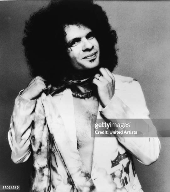 American musician Al Kooper adjusts the scarf around his neck while wearing a jacket and no shirt in this United Artists promotional photo, 1976....