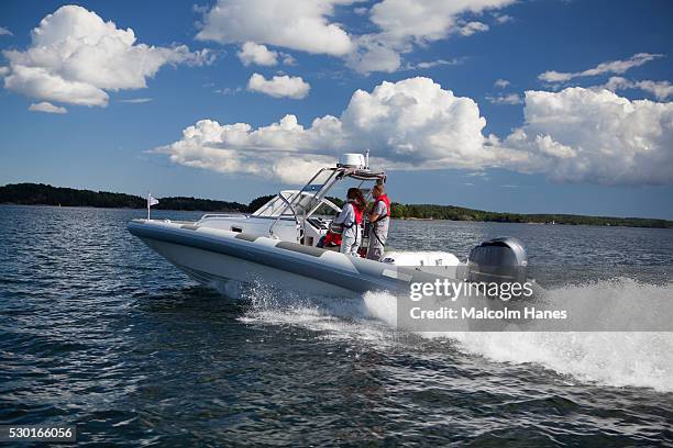 couple driving motorboat - motorboat foto e immagini stock