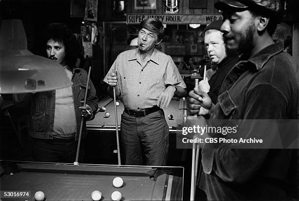 American actor Ralph Waite smokes a cigar and enjoys a game of pool with his buddies in a scene from the made-for-television movie 'The Secret Life...