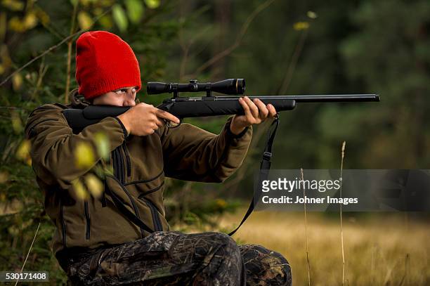 teenage boy with rifle at hunting - spy hunter stock pictures, royalty-free photos & images