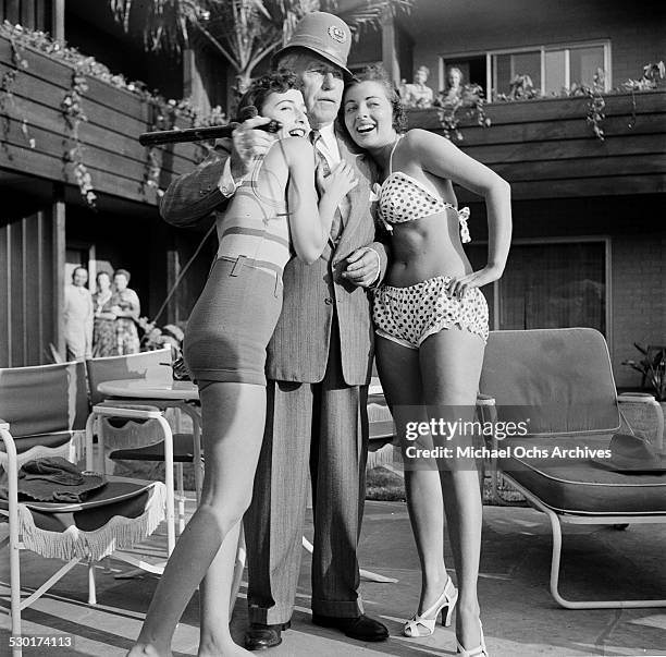 Film Director Mack Sennett wears a Keystone Cop hat as he poses with his Sennett Bathing Beauties in Los Angeles,CA.