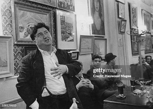 Irish author and playwright Brendan Behan singing at the Fitzroy Tavern, Charlotte Street, Fitzrovia, London, 19th June 1956. The previous evening,...