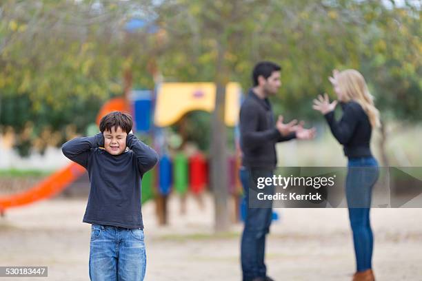 parents in conflict at playground with young boy - children divorce stock pictures, royalty-free photos & images