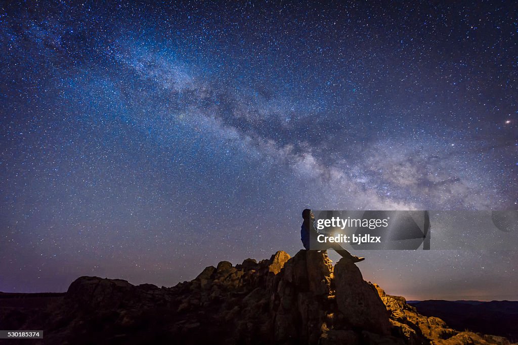 Uomo seduto sotto la Via lattea Galaxy