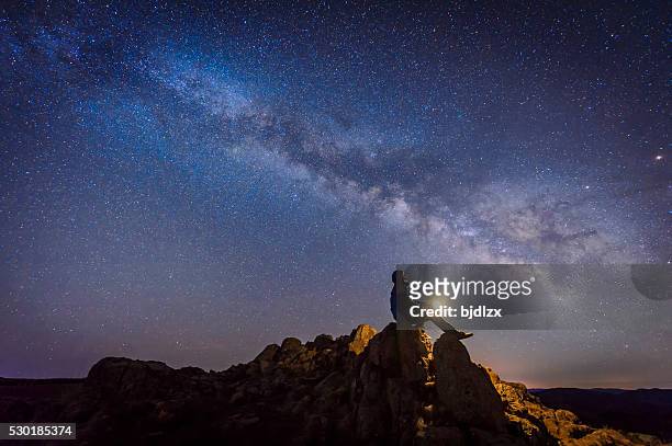 man sitting under the milky way galaxy - light natural phenomenon bildbanksfoton och bilder