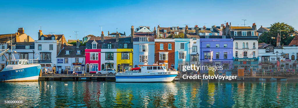 Colourful cottages in idyllic seaside fishing village harbour Dorset UK