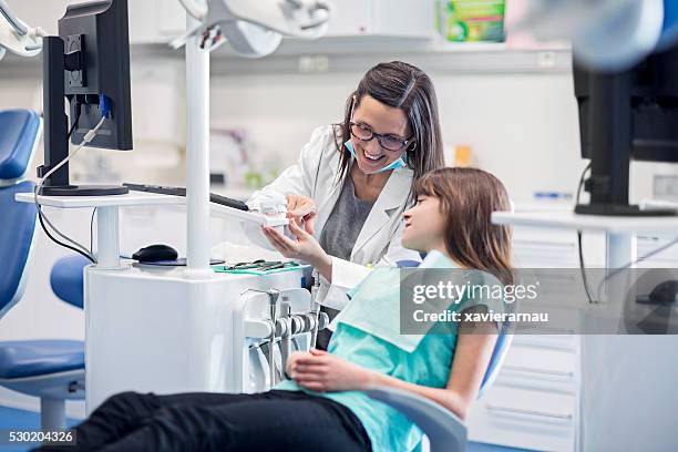 assistente del dentista mostrando denti modello da ragazza - dentista bambini foto e immagini stock