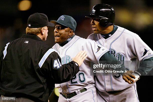 First Base Coach Billy Hatcher and Eduardo Perez of the Tampa Bay Devil Rays argue with First Base Umpire Terry Craft after Perez was called out at...