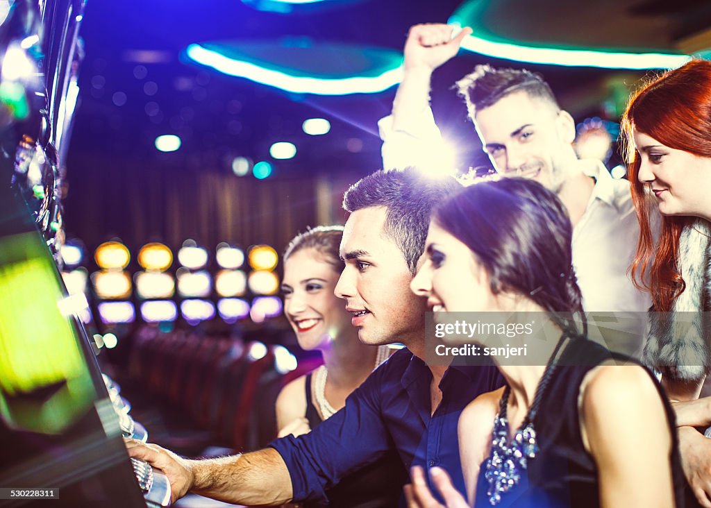 Slot Machine Player Group Of Young People Playing Slot Machines At The Casino High-Res ...