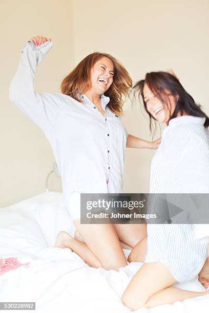 laughing friends dancing on bed - chica bailando en pijama fotografías e imágenes de stock
