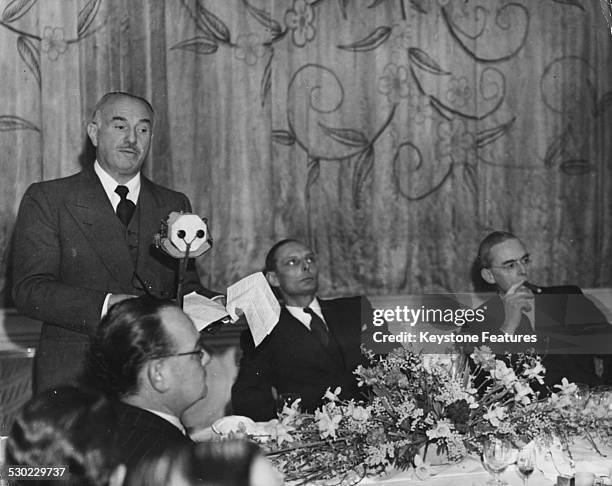 Portrait of American film executive Jack Warner, with Sir Stafford Cripps on his right, giving a speech during a luncheon at the Savoy Hotel, London,...