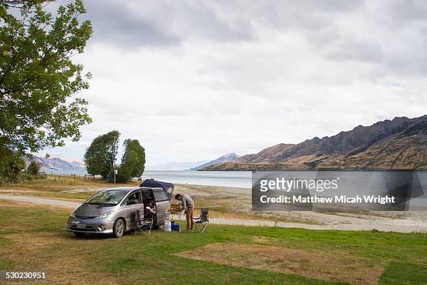 a couple prepares lunch at a campsite. - road trip new south wales stock pictures, royalty-free photos & images