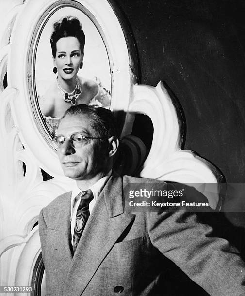 Portrait of Lou Walters, owner of the Latin Quarter nightclub on Broadway, standing in front of a picture of one of his showgirls in the background,...