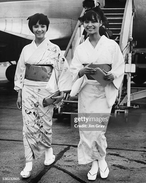 Japanese actresses Mie Hama and Akiko Wakabayashi, wearing kimono as they arrive in the UK to star in the James Bond film 'You Only Live Twice',...