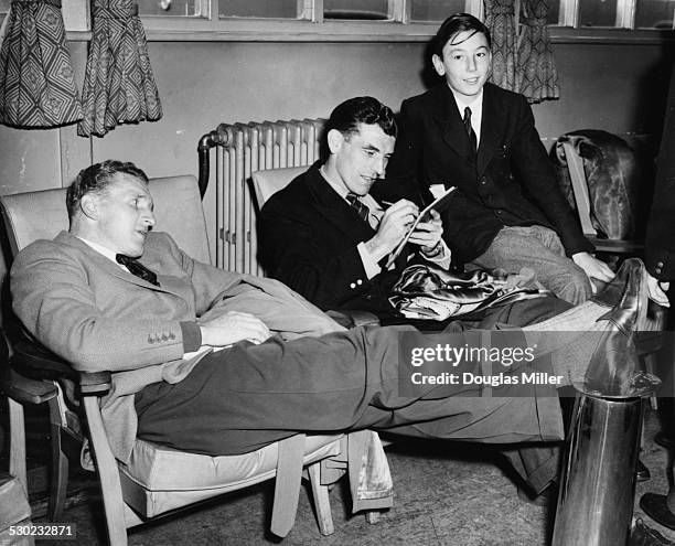 Arsenal Football Club players Alex Forbes and J Wade, signing an autograph for a young fan, at Northolt Airport on their way to play the Moscow...