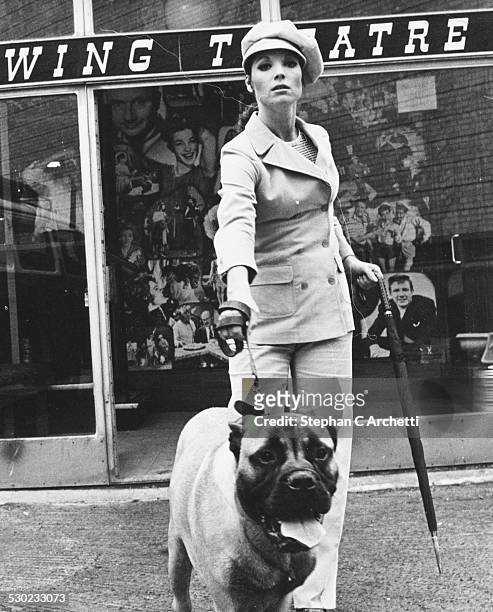 Portrait of actress Elsa Martinelli, holding a dog on a leash, and wearing a trouser suit and cap, while filming 'Maroc 7' at Pinewood Studios,...