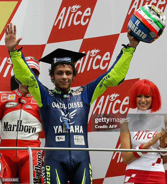 Italian Moto GP rider Valentino Rossi jubilates on the podium after winning the Italian Grand Prix at Mugello's track ahead of compatriots Max Biaggi...