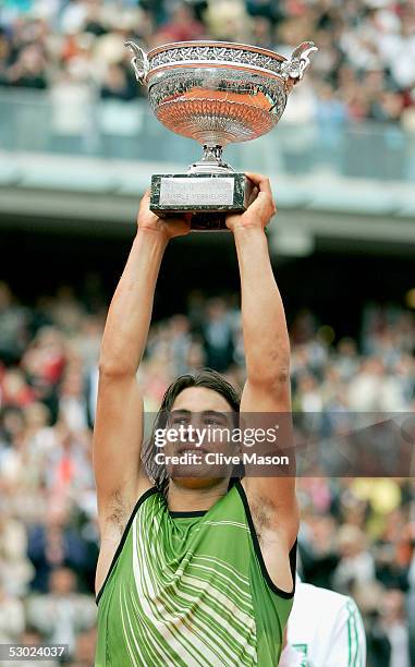 Rafael Nadal of Spain celebrates with the trophy at the end of the Mens Final match on the fourteenth day of the French Open at Roland Garros on June...