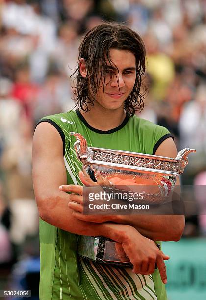 Rafael Nadal of Spain celebrates with the trophy at the end of the Mens Final match on the fourteenth day of the French Open at Roland Garros on June...