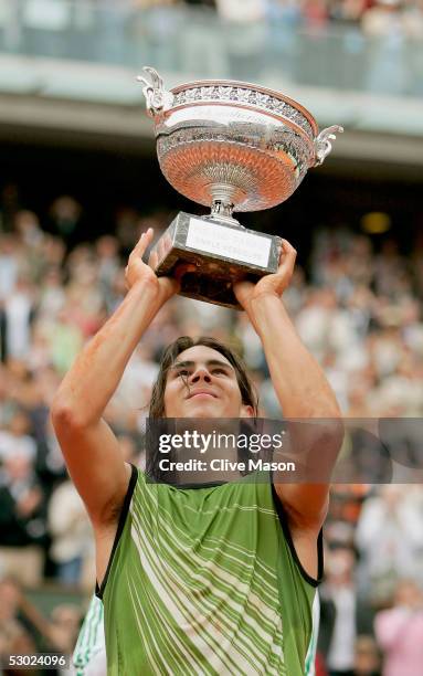 Rafael Nadal of Spain celebrates with the trophy at the end of the Mens Final match on the fourteenth day of the French Open at Roland Garros on June...