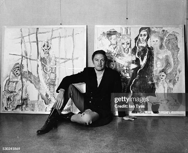 Portrait of actor Keith Michell, posing with two of his own paintings, at the John Whibley Galleries, London, circa 1968.