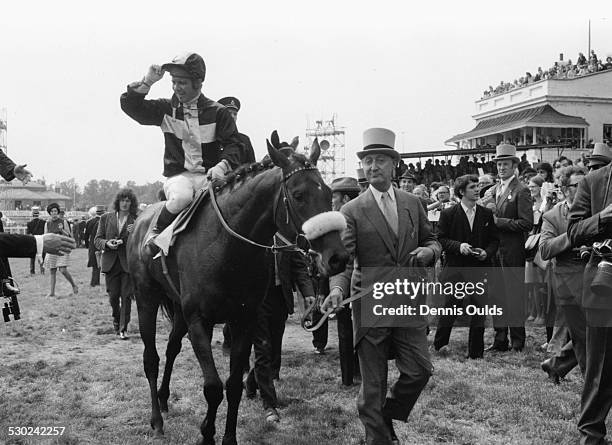 Racehorse Mill Reef, ridden by jockey Geoff Lewis, being led away by his owner Paul Mellon after his victory at the Derby at Epsom, England, June 2nd...