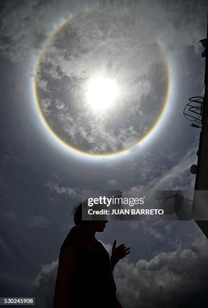 Woman is seen under a halo in Caracas on May 10, 2016. The halo is an optical phenomenon produced when light interacts with ice crystals suspended in...