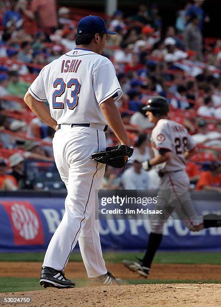 Starting pitcher Kazuhisa Ishii of the New York Mets walks back to the mound as Lance Niekro of the San Francisco Giants runs the bases after his...