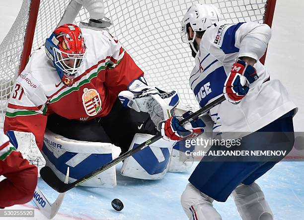 France's forward Yorick Treille attacks Hungary's goalie Miklos Rajna during the group B preliminary round game Hungary vs France at the 2016 IIHF...