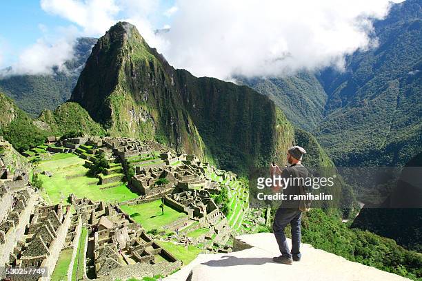 viajeros tomar fotografía con teléfono celular en machu picchu, perú - cuzco fotografías e imágenes de stock