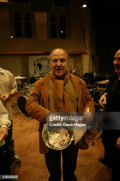 The promoter of the original Live Aid concert, Harvey Goldsmith, collects money in a bucket from the stars recording the Band Aid 20 charity single,...