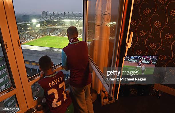 West Ham fans watch the action from a nearby block of flats during the Barclays Premier League match between West Ham United and Manchester United at...