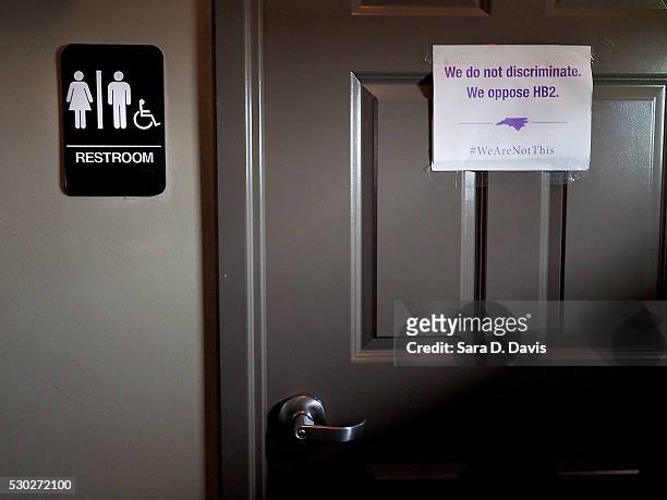 Unisex sign and the "We Are Not This" slogan are outside a bathroom at Bull McCabes Irish Pub on May 10, 2016 in Durham, North Carolina. Debate over...