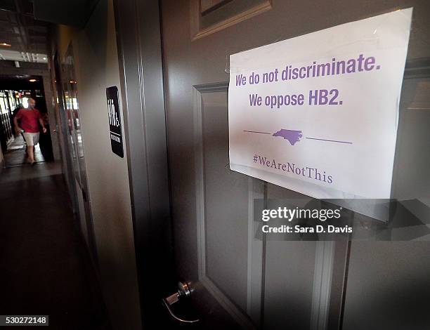 Unisex sign and the "We Are Not This" slogan are outside a bathroom at Bull McCabes Irish Pub on May 10, 2016 in Durham, North Carolina. Debate over...