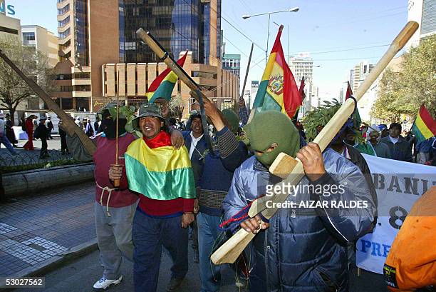 Aymara peasants march along La Paz streets carrying mock guns during a protest 06 June 2005. Bolivian opposition demonstrators rejected a church plea...