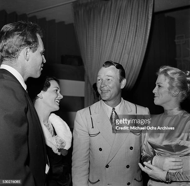 Entertainer Tex Ritter his wife Dorothy Fay talk with actor Charlton Heston and his wife Lydia Clarke as they attend the Cinema Editors Awards in Los...