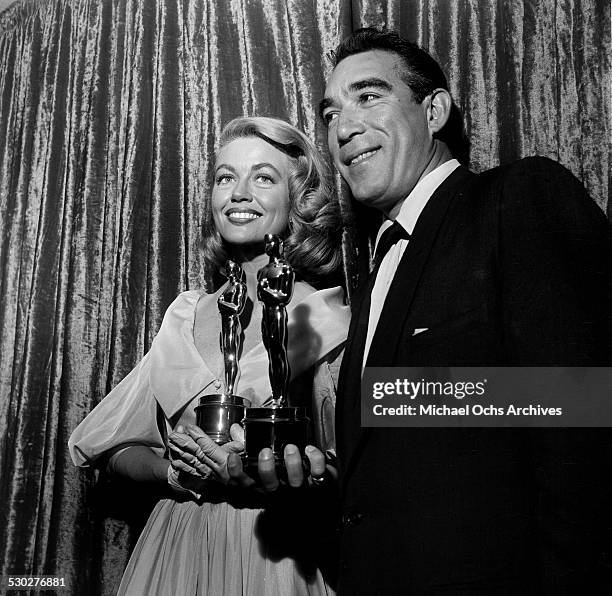 Actress Dorothy Malone and actor Anthony Quinn pose with their Oscars for Supporting Actress for "Written on the Wind" and Supporting Actor for "Lust...