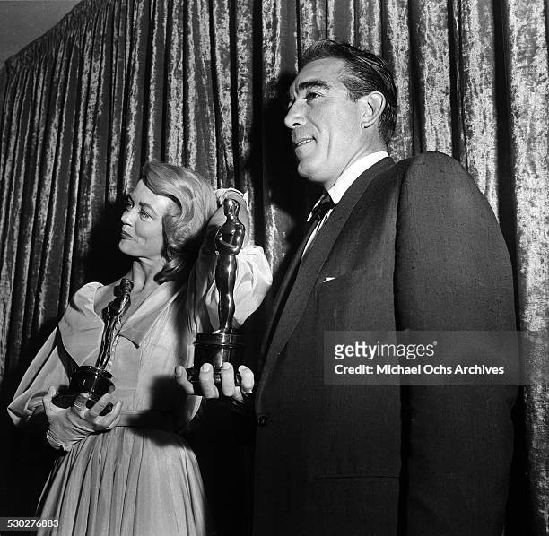 Actress Dorothy Malone and actor Anthony Quinn pose with their Oscars for Best Supporting Actress for "Written on the Wind" and Best Supporting Actor...