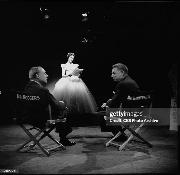 American composer Richard Rodgers and American lyricist Oscar Hammerstein II sit in directors chairs while British actress and singer Julie Andrews...