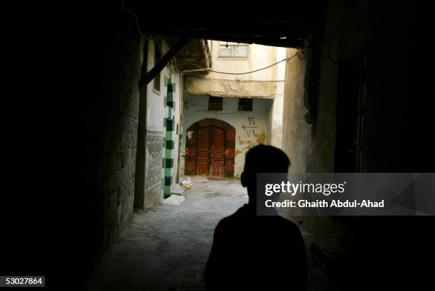 Syrian boy stands at the entrance to a street on May 21, 2005 in the old streets of Damascus, Syria. Syrian President Bashar al-Assad has vowed to...