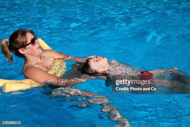 young boy learn to swim with a lifeguard - dos personas stock pictures, royalty-free photos & images