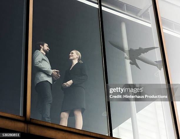 business travellers with airplane reflecting - airport business stock pictures, royalty-free photos & images