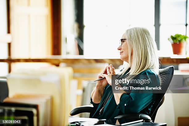 mature businesswoman listening during meeting - estilo regency fotografías e imágenes de stock