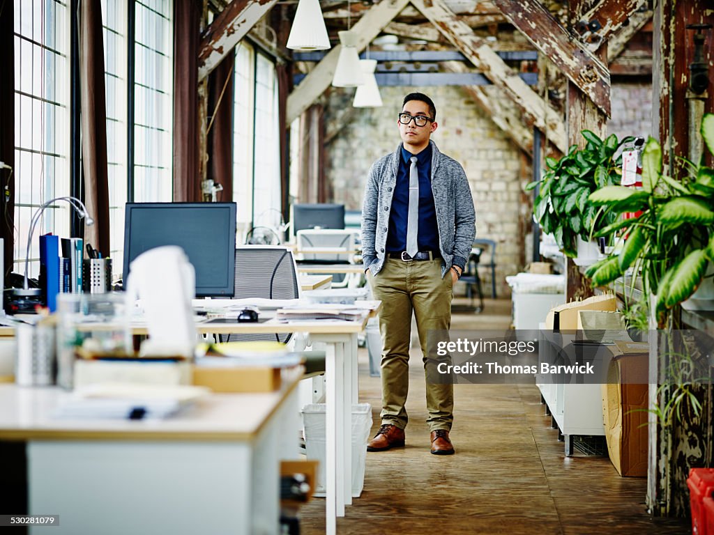 Businessman standing near workstations in office