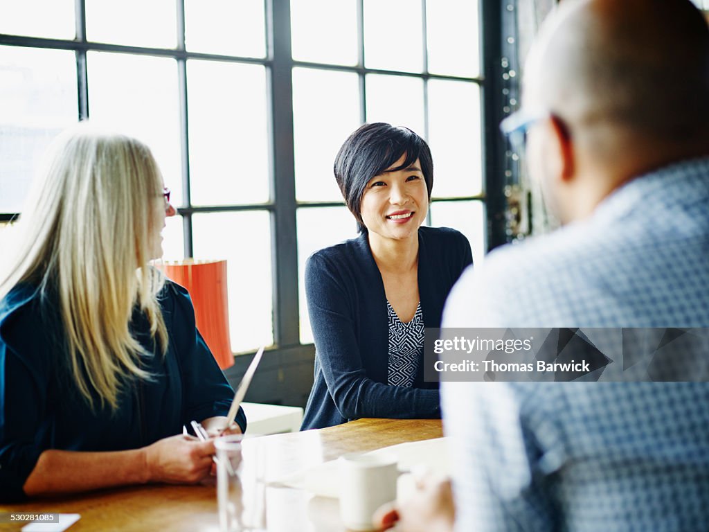 Businesswoman leading discussion with colleagues